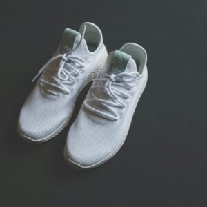 White mesh sneakers with laces shot from above against a dark surface.