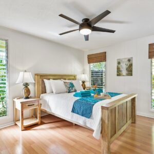 Sunny tropical bedroom with wooden furniture, teal accents, and lush greenery views.